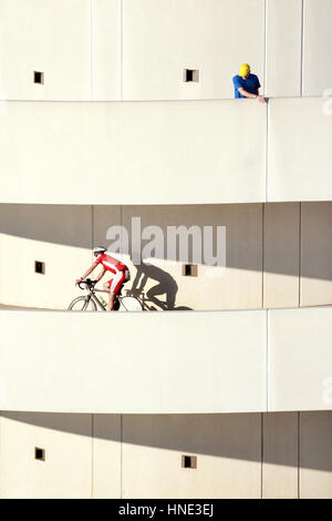 Les cyclistes sur une rampe d'entrée circulaire à structure de stationnement Banque D'Images