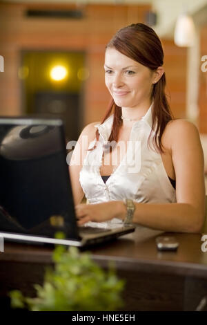 Communiqué de modèle, Junge Frau sitzt im Kaffeehaus an der Theke und arbeitet suis coffre - young woman using laptop in cafeteria Banque D'Images