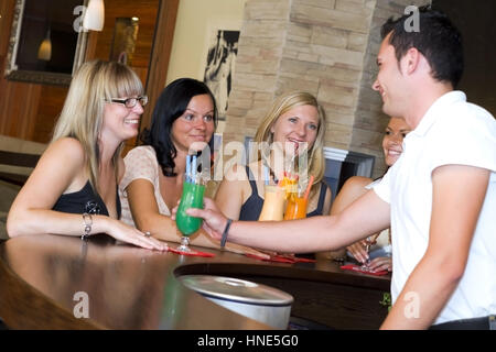 Communiqué de modèle, Junger Kellner flirtet mit vier Frauen an der Bar - barman coquets avec quatre femmes au bar Banque D'Images