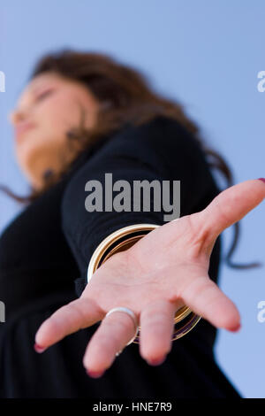 Femme hispanique avec bras ouverts dans la prière. Banque D'Images