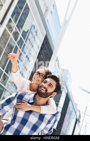 Happy woman montrant quelque chose à l'homme tout en appréciant in city Banque D'Images