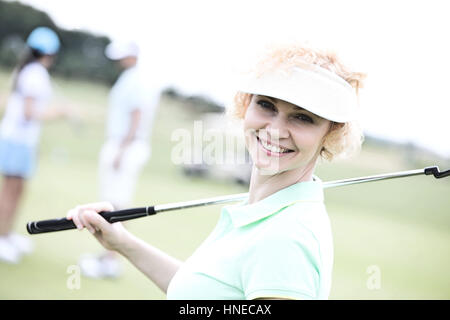 Portrait of happy female golfer holding golf club Banque D'Images