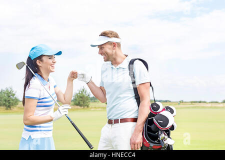 Cheerful friends offrant un rapport de cinq parcours de golf à Banque D'Images