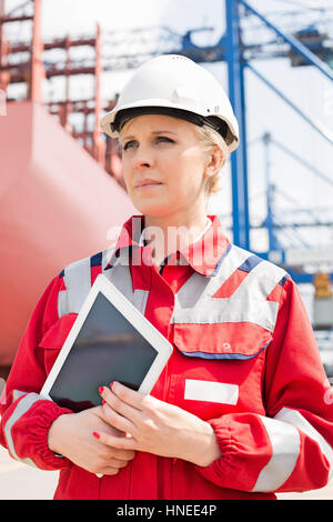 Ingénieur femelle holding tablet computer in shipping yard Banque D'Images