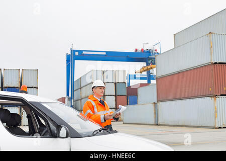 Homme d'âge moyen l'examen de la cargaison en cour d'expédition Banque D'Images Homme d'âge moyen l'examen de la cargaison en cour d'expédition Banque D'Images