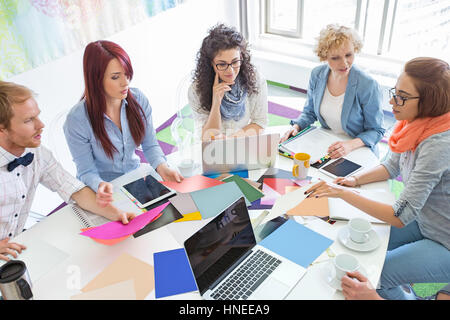 High angle view of businesspeople analyser des photographies dans creative office Banque D'Images