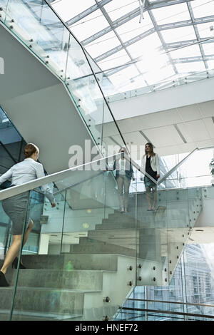 Businesswomen walking on steps in office Banque D'Images