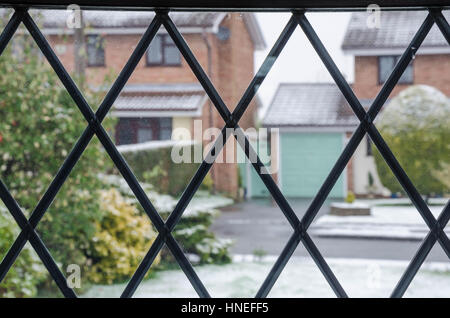 À la recherche par le biais d'une fenêtre en verre au plomb, les maisons en face de l'autre côté de la route. Banque D'Images