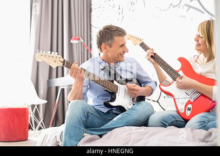 Heureux père et fille jouer la guitare à la maison Banque D'Images