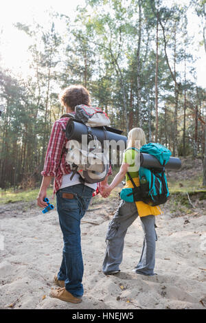 Vue arrière du couple avec des sacs de randonnée balade en forêt Banque D'Images