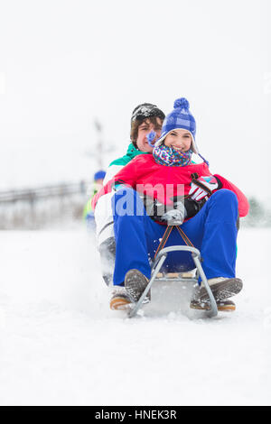 Full Length portrait of young couple traîneau dans la neige Banque D'Images