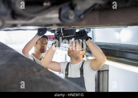 Les ingénieurs de maintenance réparation de voiture en atelier Banque D'Images