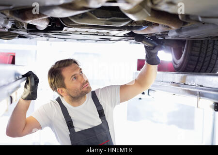 Réparation de voiture de l'examen des travailleurs masculins dans l'atelier Banque D'Images