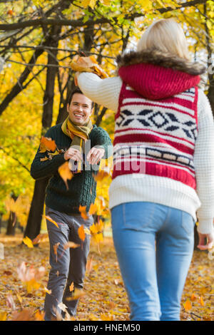 Happy young couple Playing with autumn leaves in park Banque D'Images