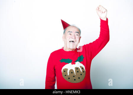 Senior adult man wearing Christmas jumper élever son bras en l'air Banque D'Images