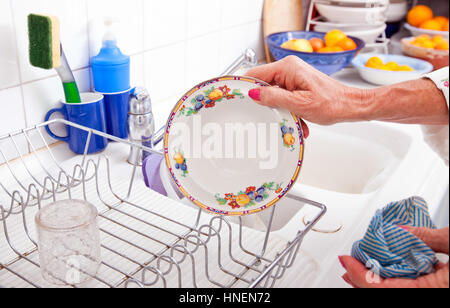 Portrait of senior woman organiser plaque dans rack au comptoir de la cuisine Banque D'Images