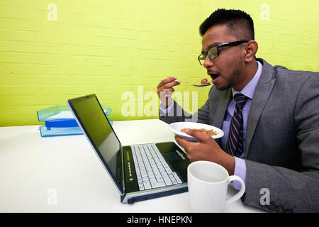 Homme d'affaires indien de manger à son bureau. Banque D'Images