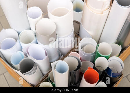 Tas de rouleaux de papier d'impression et de films de différentes couleurs dans des boîtes en carton sur le carrelage de la chambre d'impression Banque D'Images