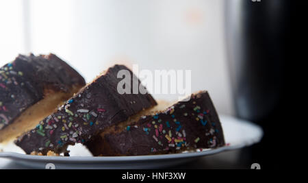 Image horizontale de trois tranches de gâteau au chocolat maison avec black tasse sur fond tourné avec lumière du jour Banque D'Images