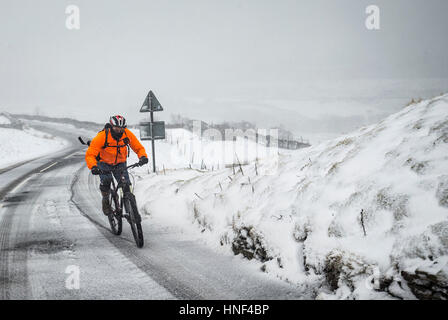 PA Meilleur un cycliste sur le Buttertubs passent dans le Yorkshire Dales comme la neige hits au Royaume-Uni. Banque D'Images