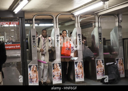 Les banlieusards passent par des tourniquets à 47-50th Sts. La station de métro Rockefeller Center au cours de la soirée l'heure de pointe dans le centre de Manhattan. Banque D'Images