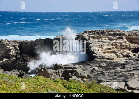 Vagues de l'Océan indien à travers le passage de pierre calcaire naturelle au Cap Vlamingh à Rottnest Island, dans l'ouest de l'Australie. Banque D'Images