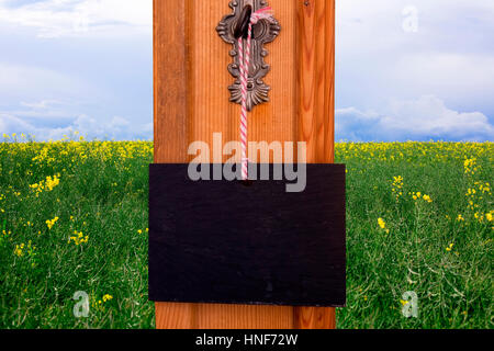 Petit tableau noir accroché en face de Clés domaine de fleurs jaune Banque D'Images