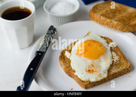 Toast avec oeuf au plat déjeuner on white plate Banque D'Images