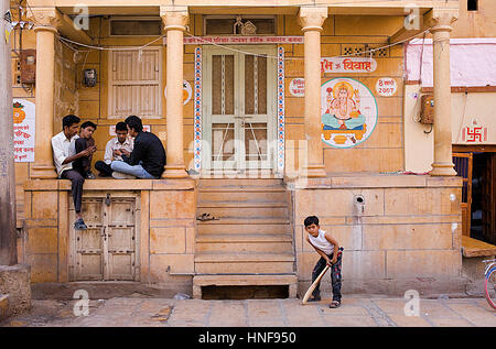 Cartes à jouer l'homme et le garçon à jouer au cricket, scène de rue, Jaisalmer, Rajasthan, India Banque D'Images