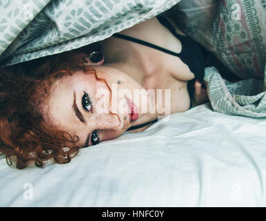 Portrait d'une jeune femme rousse dans sa chambre à coucher Banque D'Images