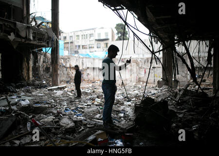 Téhéran, Iran. 12 Février, 2017. Un Iranien de propriétaires prend des photos de sa boutique à l'effondrement d'un immeuble commercial du site, à Téhéran, capitale de l'Iran, le 12 février 2017. Au moins 30 personnes ont été tuées dans l'effondrement d'un édifice de 16 étages le Jan 19, appuyez sur TV signalés. Credit : Ahmad Halabisaz/Xinhua/Alamy Live News Banque D'Images