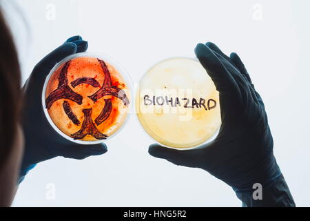 Mains ont pétri avec biohazard symbole mot signe. L'eau contaminée food concept. Maladies infectieuses dangereuses. Des tests de laboratoire médical de la recherche. Banque D'Images