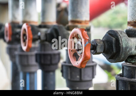 Ancien robinet d'eau et branchez le tuyau de la pompe dans le lac dans un parc public, l'accent avant arrière-plan flou. Banque D'Images