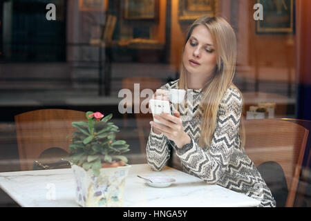Belle fille à l'aide de son téléphone portable dans le café. Vie Ville Banque D'Images