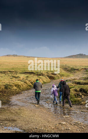 Une famille de marcher le long d'un sentier boueux sur Tor, Bodmin Moor, Cornwall. Banque D'Images