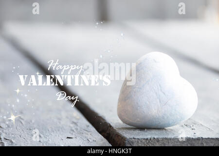 Cœur sur une table en bois et Happy Valentines Day texte, photo floue pour le fond Banque D'Images