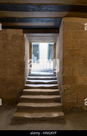 De dark passage voûté et étroit escalier menant à l'extérieur petit hall d'accueil avec deux fenêtres en bois jaune, Le Caire, Égypte médiévale Banque D'Images