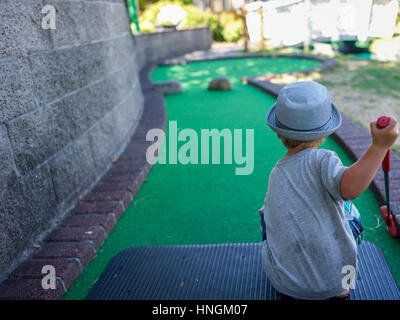 Petit garçon bambin jouer au mini-golf ou mini-golf à un mini-golf en été Banque D'Images