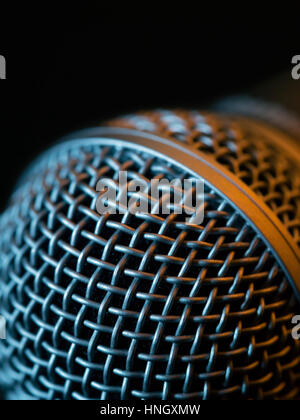 Photo macro d'un microphone vocal en faible lumière allumée avec stage lights. Banque D'Images