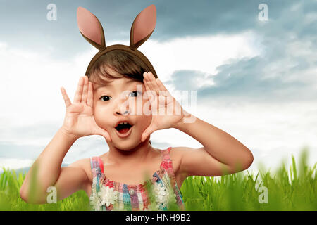 Asian girl avec oreilles de lapin le jour de Pâques dans la prairie Banque D'Images