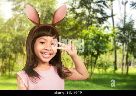 Jeune fille avec des oreilles de lapin dans le jardin Banque D'Images