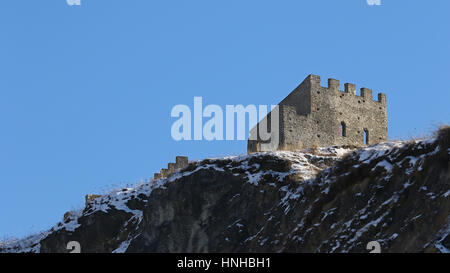 Ruines médiévales du générique sur le bord d'une falaise dans la neige de l'hiver contre un ciel bleu Banque D'Images