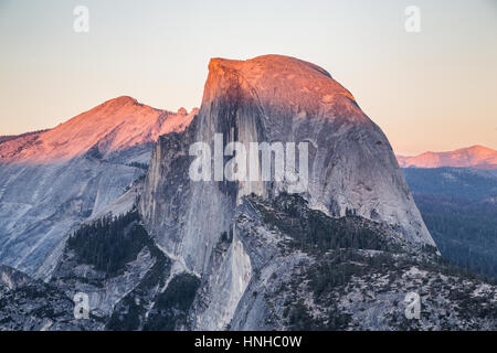 La vue classique du célèbre Demi Dôme allumé dans la belle lumière du soir au coucher du soleil d'or sur une journée ensoleillée avec ciel bleu, Yosemite National Park, États-Unis Banque D'Images