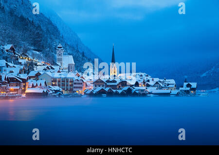 Vue de carte postale classique de la célèbre ville au bord du lac de Hallstatt dans les Alpes en mystic twilight à l'aube d'un jour brumeux froid en hiver, Salzkammergut, Autriche Banque D'Images