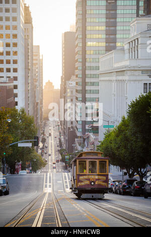 La vue classique du téléphérique historique équitation sur la célèbre rue de la Californie dans la belle lumière du matin d'or au lever du soleil en été, San Francisco, États-Unis Banque D'Images