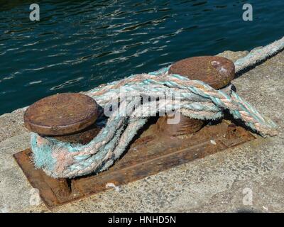 Rusty bollard sécurisé avec corde d'amarrage au quai Banque D'Images