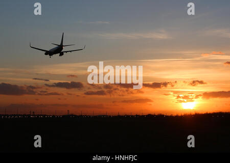 Avion de Boeing 737 à l'atterrissage à l'aéroport de Stansted sur la piste 22 comme le soleil se couche. Banque D'Images