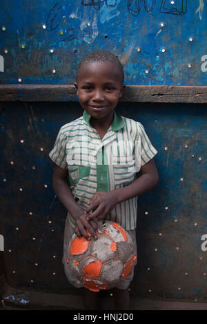 Garçon avec un ballon de football dans l'orphelinat, les bidonvilles de Kibera, Nairobi, Kenya, Afrique de l'Est Banque D'Images