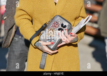 Femme avec l'argent, pierres précieuses décorées, sac et Manteau en laine jaune avant de Dirk Bikkembergs fashion show, Milan Fashion Week street style ? Banque D'Images