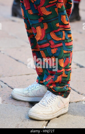 Avec l'homme blanc et coloré irisé chaussures Nike pantalon avant de Salvatore Ferragamo fashion show, Milan Fashion Week street style. Banque D'Images